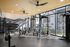 Bright and modern fitness center with state-of-the-art equipment, large windows, and a mountain mural backdrop.
