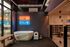 Luxury wellness space featuring a modern ice bath, vibrant hot and cold neon signs, and a sleek glass-door sauna.