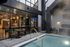 Modern apartment patio with a cozy outdoor seating area, sleek glass windows, and a luxurious poolside ambiance.