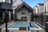 Luxurious outdoor area featuring a heated pool and modern seating under a stylish pavilion with a fireplace, perfect for relaxation.