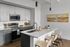 Modern kitchen with sleek gray cabinetry, stainless steel appliances, and a chic island with barstools, ideal for contemporary living.