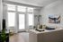Bright and inviting living room with large windows, elegant floor lamp, cozy sectional sofa, and artistic wall tapestry.