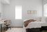 Bright and cozy bedroom featuring a stylish desk, plush bedding, and minimalist wall art, perfect for relaxation and study.