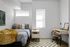 Modern bedroom with cozy bed, stylish desk, and natural light from large windows. Perfect for relaxation and productivity.