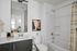 Modern and elegant bathroom featuring a sleek vanity, large mirror, and inviting bathtub under soft natural light.