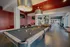 Luxurious recreation room featuring elegant pool tables, vibrant red walls, and modern lighting, perfect for leisure and entertainment.