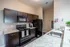 Modern kitchen with sleek dark cabinets, granite countertops, and stainless steel appliances for a stylish cooking experience.