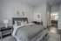 Chic bedroom showcasing modern decor, inviting bed with plush pillows, and a glimpse into an elegant en suite bathroom.