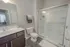 Modern bathroom with elegant glass shower, sleek vanity, and ambient lighting.