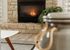 Cozy living room with a charming stone fireplace, warm lighting, and stylish decor accents.