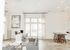 Bright and airy open-concept living space with modern furnishings, showcasing a stylish office area and chic dining setup.