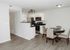 Inviting open-concept kitchen and dining area with sleek stainless steel appliances and elegant furnishings, ideal for modern living.