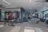 Modern apartment gym with floor-to-ceiling mirrors, high-end fitness equipment, and abundant natural light creating an inviting workout space.