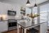 Modern kitchen with sleek white cabinets, stainless steel appliances, and chic island with pendant lighting.