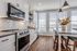 Bright, modern kitchen featuring sleek white cabinetry, stainless steel appliances, and a stylish island with seating, perfect for entertaining.