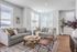 Modern living room with cozy gray sofas, stylish wooden coffee table, and abundant natural light, perfect for relaxation and entertaining.