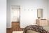 Inviting bedroom features a cozy blanket on the bed, sleek dresser with mirror, and spacious walk-in closet with elegant wood flooring.