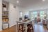 Bright and stylish open-concept living space with a modern kitchen island, cozy living room, and large windows offering a sunny view.