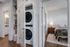Inviting apartment interior with a cozy bedroom, modern in-unit laundry, and elegant bathroom features, enhanced by warm wooden flooring.