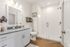 Elegant bathroom with modern fixtures, glass shower, and sleek white vanity, offering a bright and cozy atmosphere.