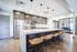 Modern kitchen with sleek stainless steel appliances, elegant pendant lighting, and a spacious island with stylish bar stools.