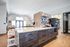 Sleek and modern kitchen lounge area featuring a stylish island with ample storage, eye-catching geometric backsplash, and ample natural lighting for a welcoming atmosphere.
