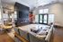 Modern and inviting living room with sleek decor, large windows, and a built-in fireplace, ideal for relaxing or entertaining.