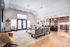 Spacious open-concept living room with modern furniture, stylish lighting, and a sleek kitchen featuring a breakfast bar.
