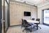 Modern conference room featuring stylish acoustical panels, sleek round table, and ergonomic office chairs, ideal for collaborative meetings.
