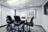 Modern meeting room with sleek high-top chairs and contemporary decor, offering a bright and professional workspace.
