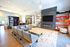 Contemporary apartment lounge featuring sleek seating, stylish shelving, and a modern fireplace beneath a wall-mounted TV, perfect for relaxation and community events.