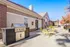 Charming patio area featuring a sleek stainless steel grill and vibrant yellow seating, ideal for outdoor gatherings in a serene setting.