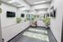 Inviting yoga studio with mirrored walls, vibrant green yoga mats, lush plants, and a relaxing atmosphere.