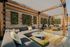 Chic outdoor patio with modern seating, vibrant yellow chairs, lush vertical garden, and shaded pergola. Perfect for relaxation and entertaining.