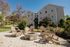Inviting outdoor seating area with Adirondack chairs and a central fire pit, set against a backdrop of a modern apartment building and landscaped greenery.