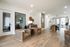 Elegant, inviting open-concept living space featuring chic leather chairs, modern decor, and warm wood flooring, perfect for relaxation and entertaining.
