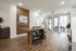 Inviting modern living area featuring a sleek wooden table, stylish bar stools, and an abundance of natural light, perfect for entertaining or relaxation.