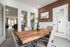 Elegant modern meeting room with a rustic wooden table, sleek gray chairs, and tasteful decor, perfect for creative discussions.