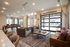 Luxurious community lounge featuring stylish seating, modern pool table, and glass garage doors opening to a poolside view.