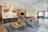 Elegant communal living space featuring modern lighting, cozy seating areas, a stylish bar counter with stools, and a well-equipped game zone with pool and foosball tables.