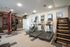 Modern fitness center equipped with state-of-the-art treadmills, versatile exercise equipment, and a sleek staircase trainer.