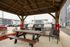 Charming outdoor pavilion with modern grills and a cozy picnic area, set amidst stylish apartment buildings.