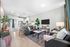 Chic open-plan living space with elegant decor, featuring a cozy seating area, stylish kitchen, and large windows inviting natural light.
