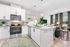 Contemporary open-plan kitchen and living area featuring modern appliances, elegant granite countertops, and stylish decor.