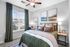 Cozy bedroom with stylish decor, featuring a plush bed, contemporary artwork, and a sunlit window with elegant drapes.