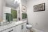 Elegant bathroom with granite countertop, stylish fixtures, and green accents enhancing a serene ambiance.
