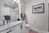 Modern bathroom with elegant granite countertop, stylish wall art, and ambient lighting, offering a chic and cozy atmosphere.