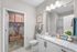 Bright and modern bathroom with sleek granite countertops, stylish decor, and a spacious walk-in closet.