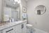 Elegant bathroom with granite countertop, stylish mirror, and modern decor, offering a serene and luxurious feel.