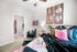 Modern bedroom with plush bedding, vibrant wall art, and stylish decor leading to an en-suite bathroom. Cozy and inviting space perfect for relaxation.